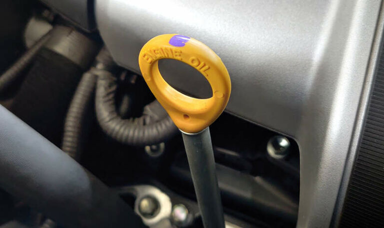 Locate engine oil dipstick under the hood